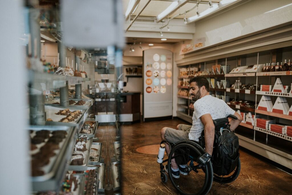 a man in a wheelchair browsing chocolate treats