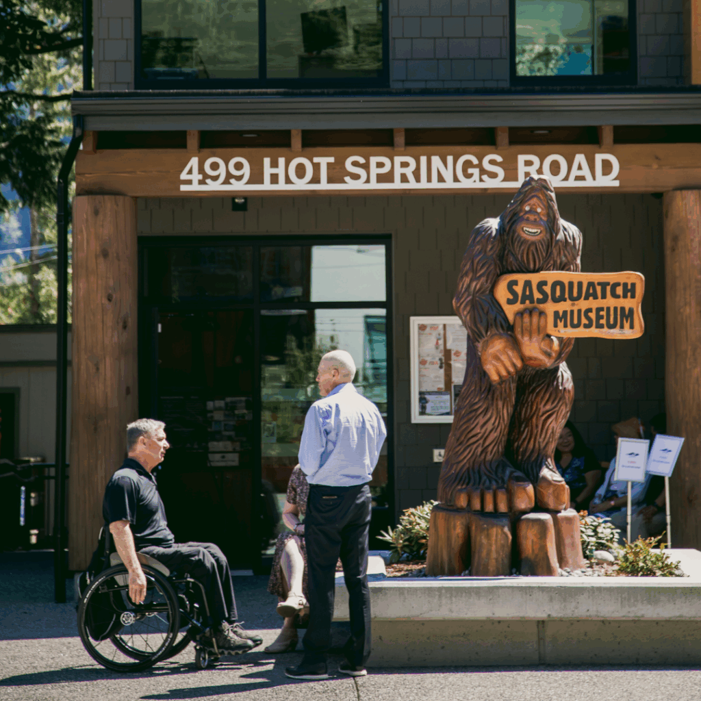a man in a wheelchair talking with a man outside a building