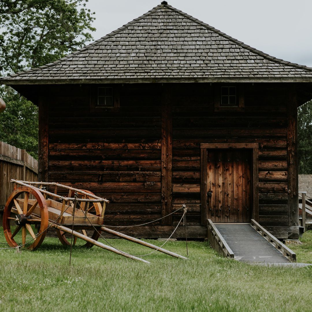 a wheelbarrow next to a wooden building