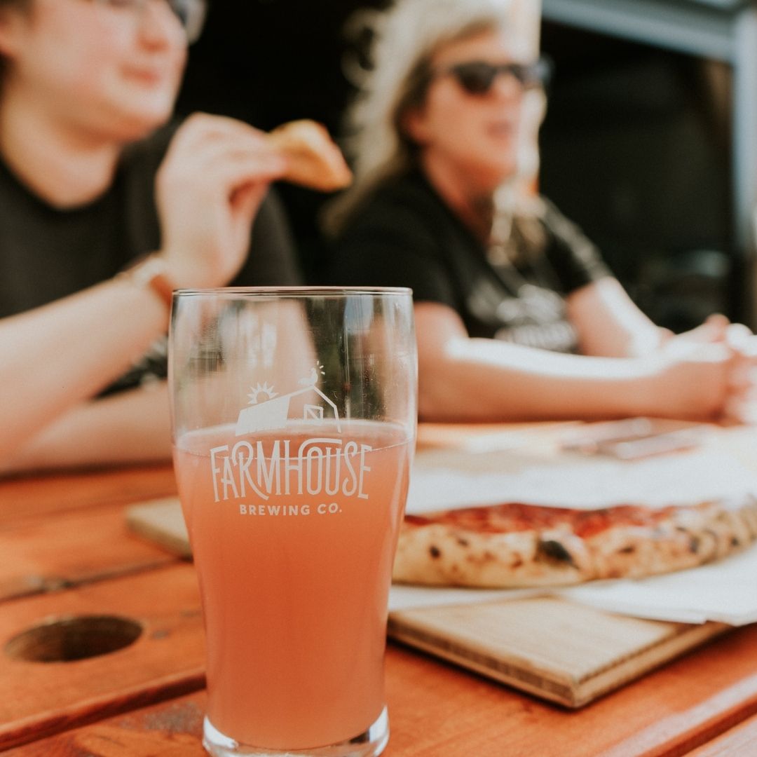 a glass of beer in front of a pizza