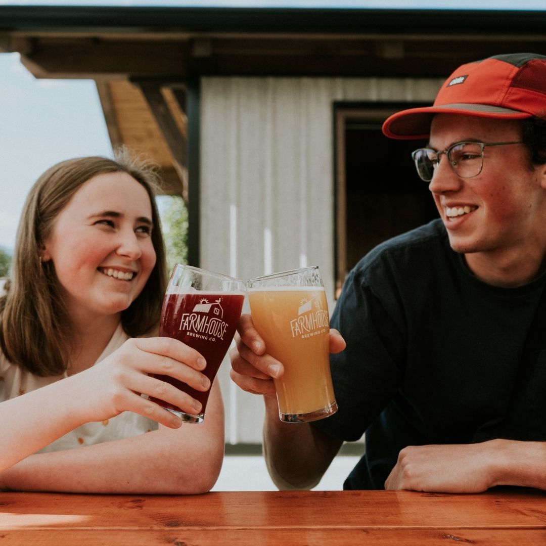 a man and woman clink beer glasses