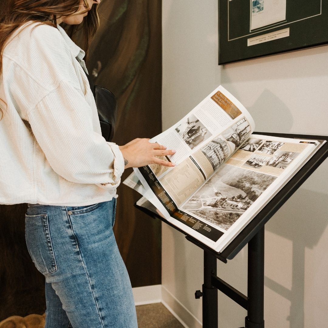 a woman reading a large book on a stand