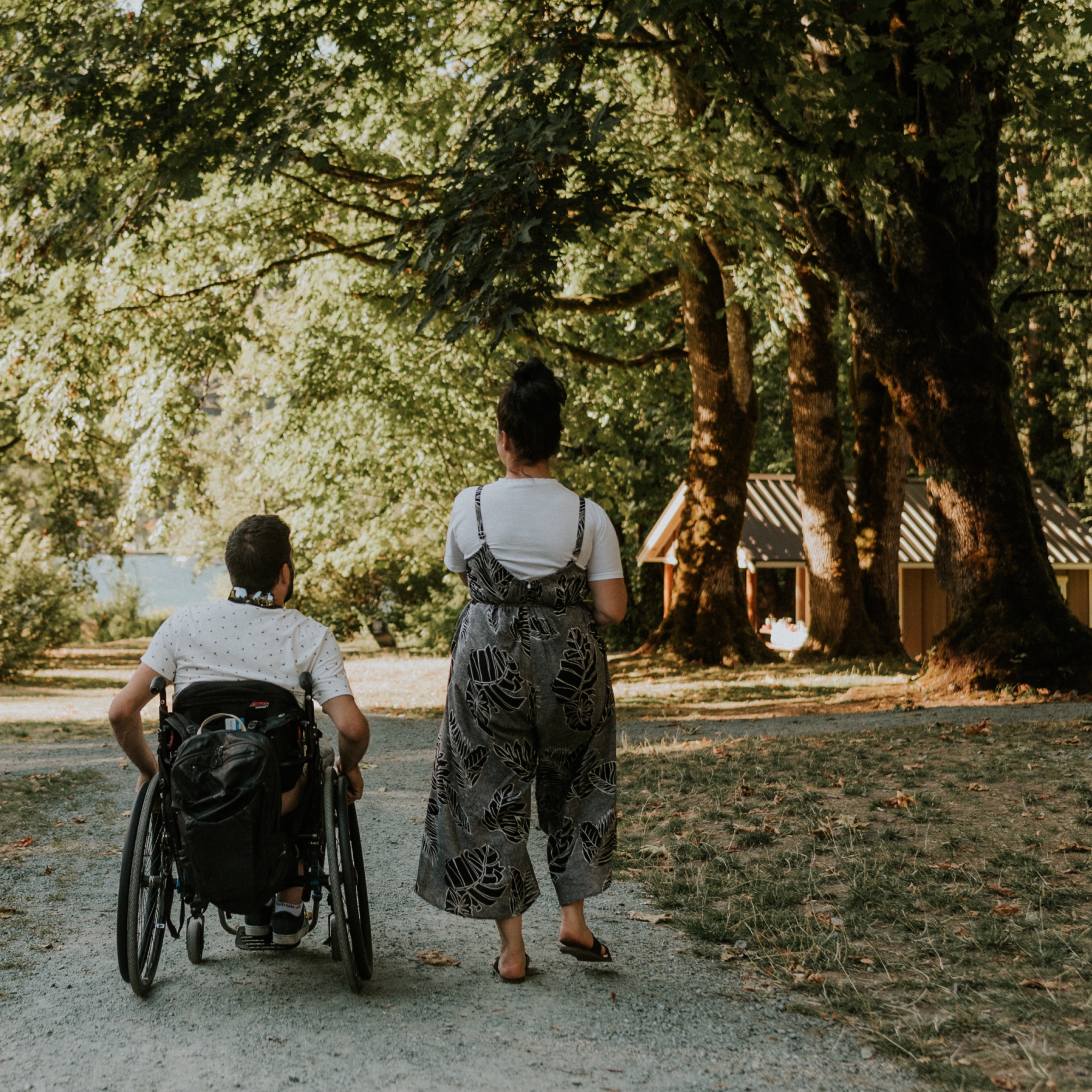 a woman and man in a wheelchair on a campground path