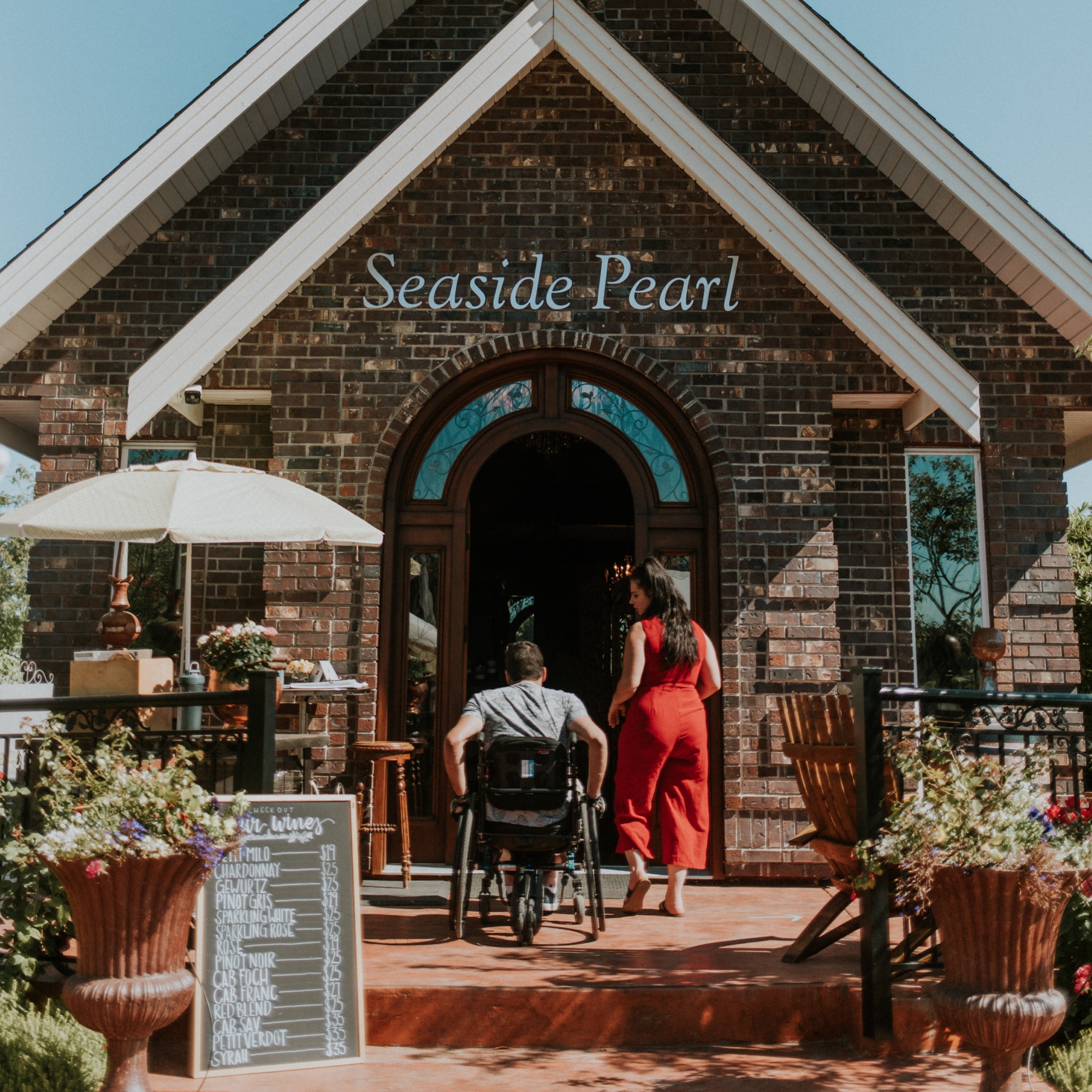 a woman and man in a wheelchair enter a winery