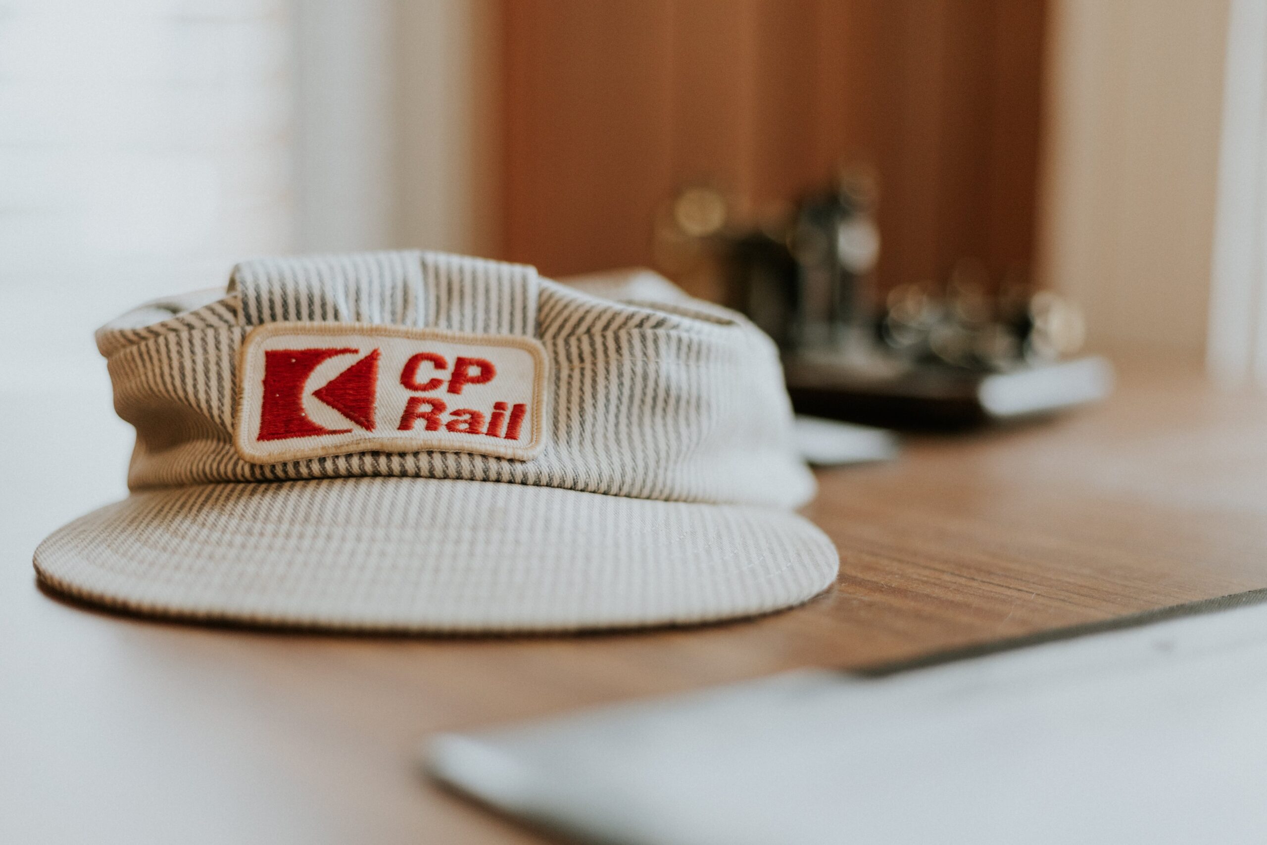 A train conductor's hat, sitting on a desk.