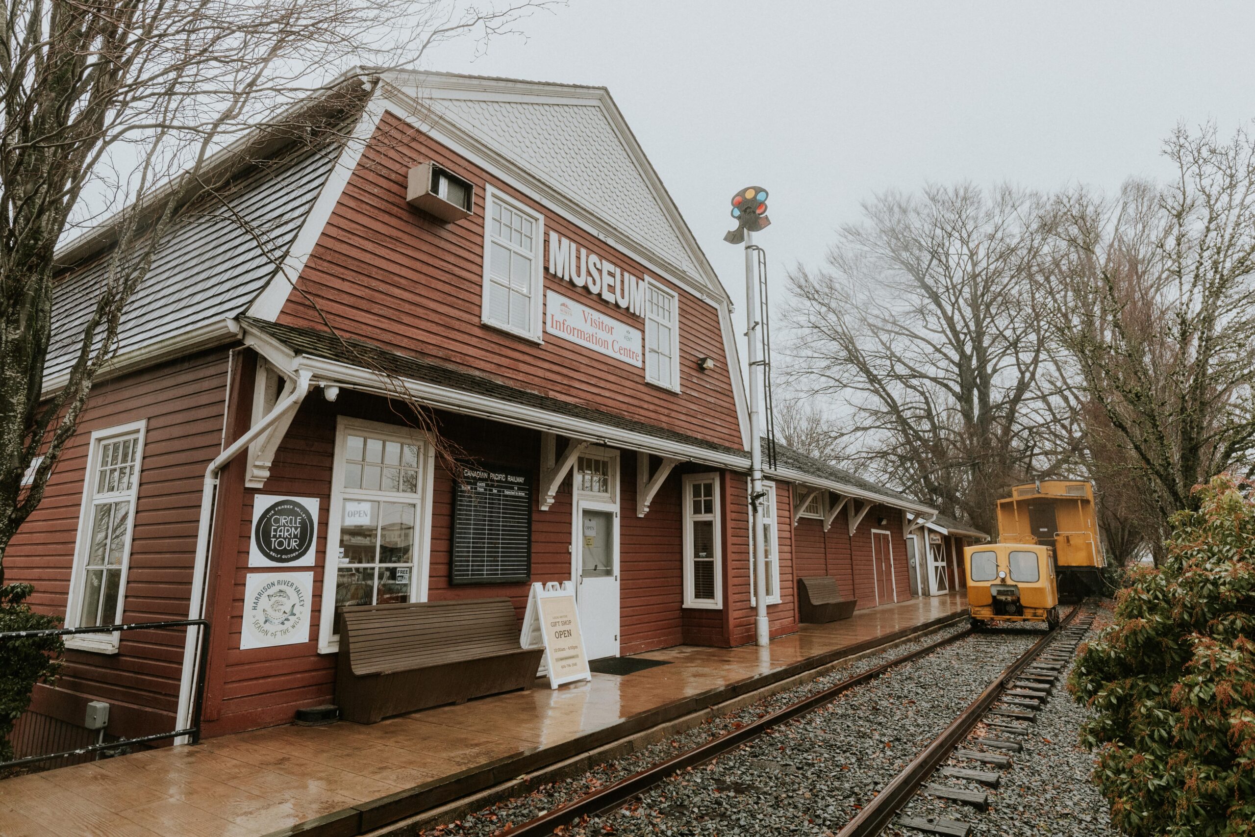 An operational train moving along the tracks, in front of a red barn-looking museum