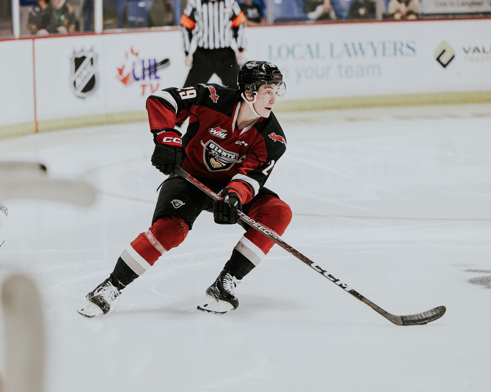 A hockey player on the ice with his hockey stick ready for action