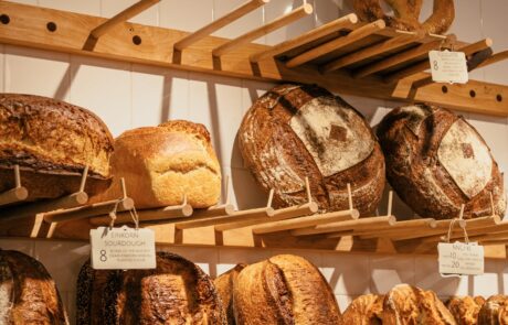 A variety of breads neatly arranged on a shelf, showcasing different shapes, sizes, and textures.