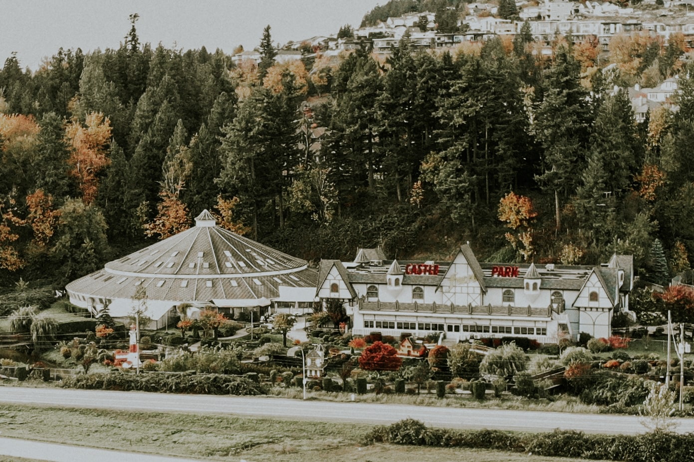 A spacious white building nestled amidst trees.