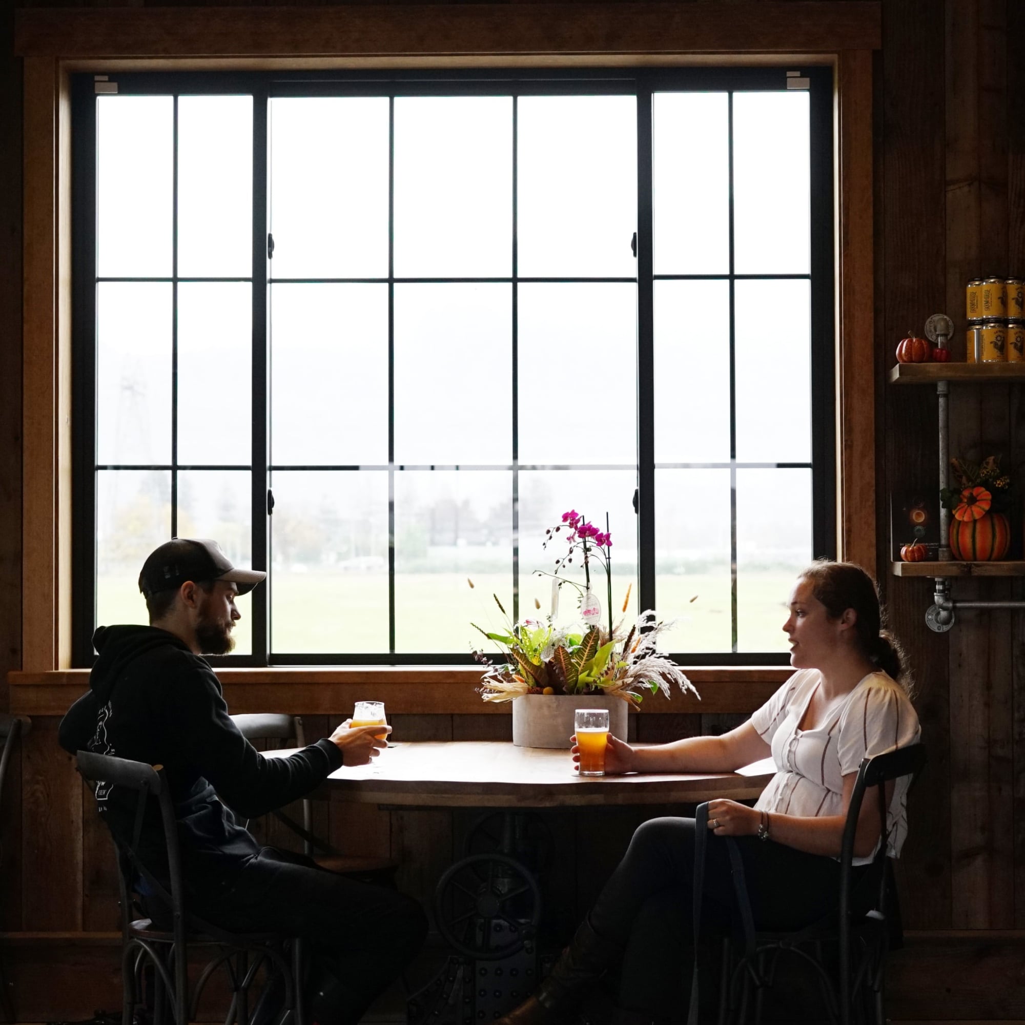 A man and woman sitting near a window at a table.