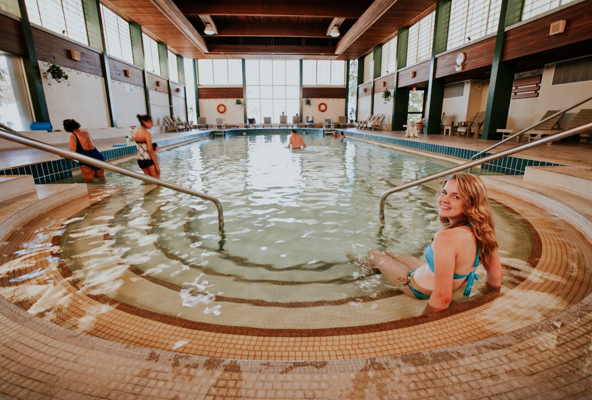 A woman sitting serenely in an indoor pool