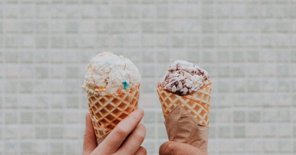 Two hands holding ice cream cones