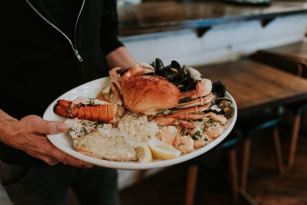 A plate of seafood being carried by a server.