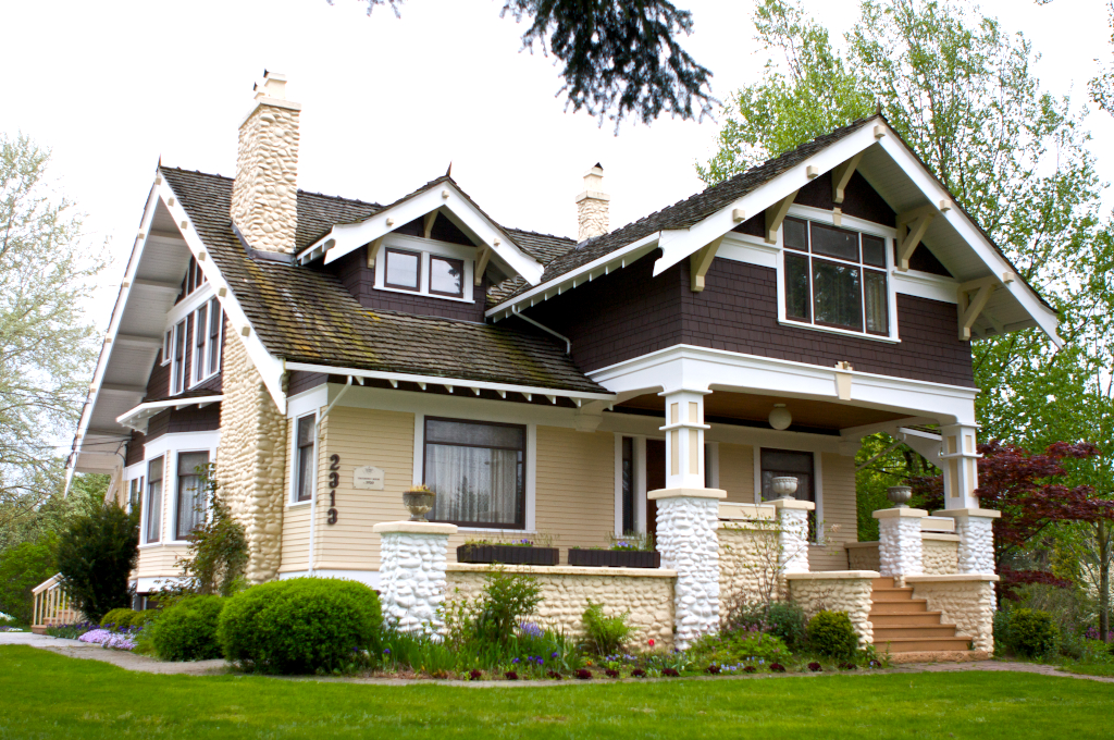 A yellow house with a grassy lawn in front.