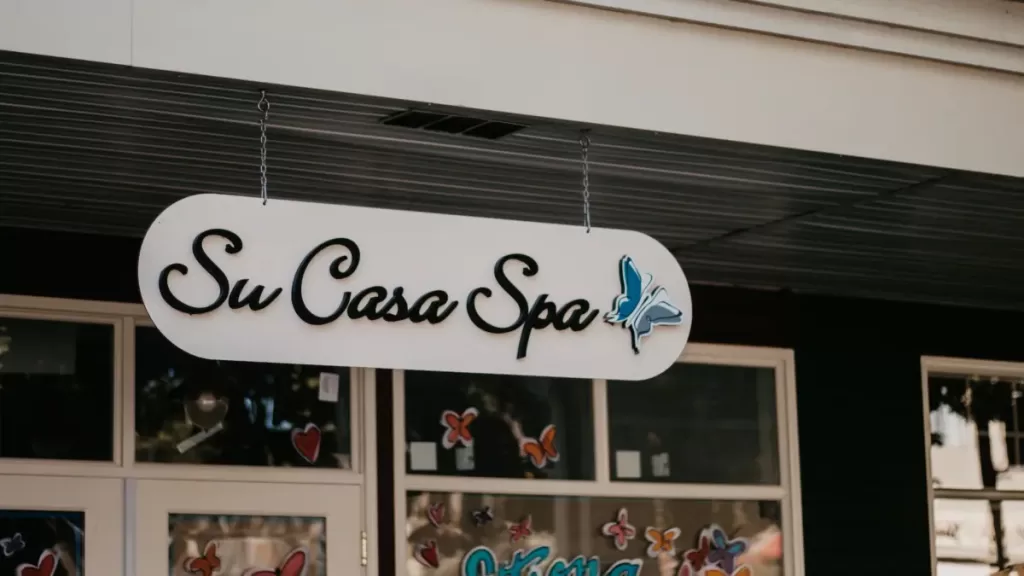 A sign that says Su Casa Spa hanging outside a store.