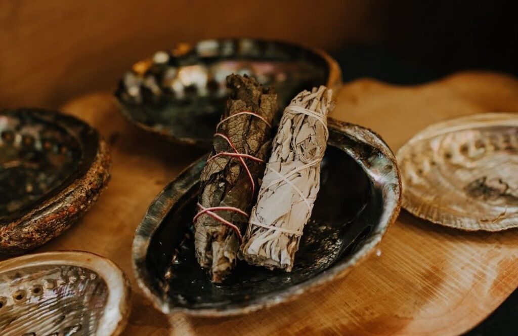 Two bundles of sage sit in a small bowl.
