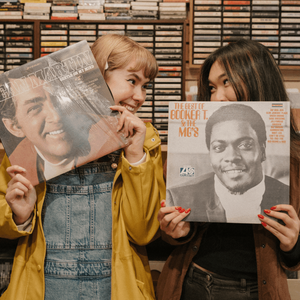 two people pose with vinyl records