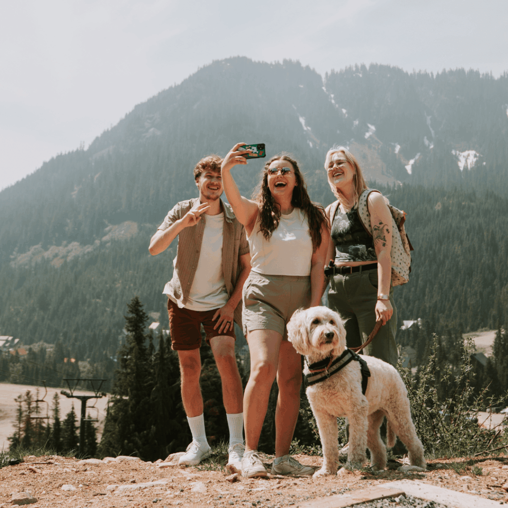 3 people and a dog pose for a selfie