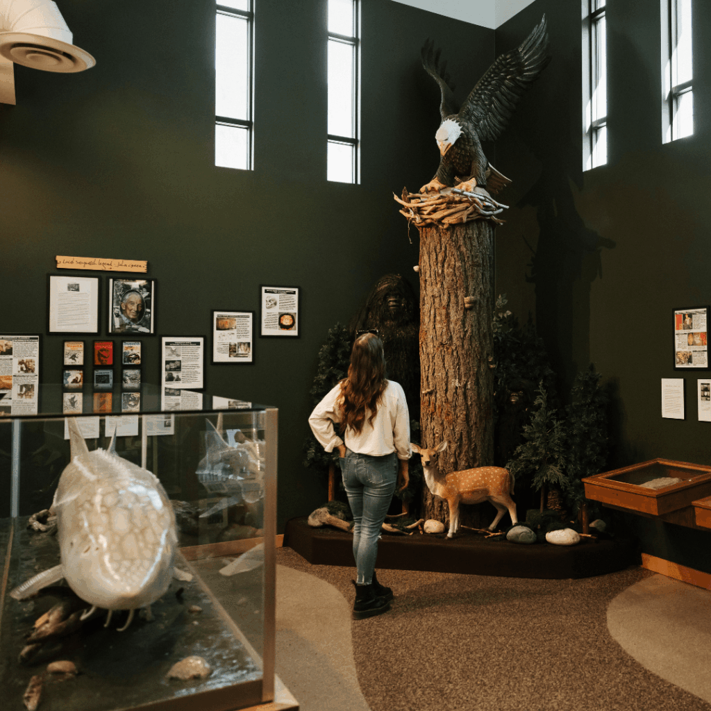 a woman looking at an eagle sculpture