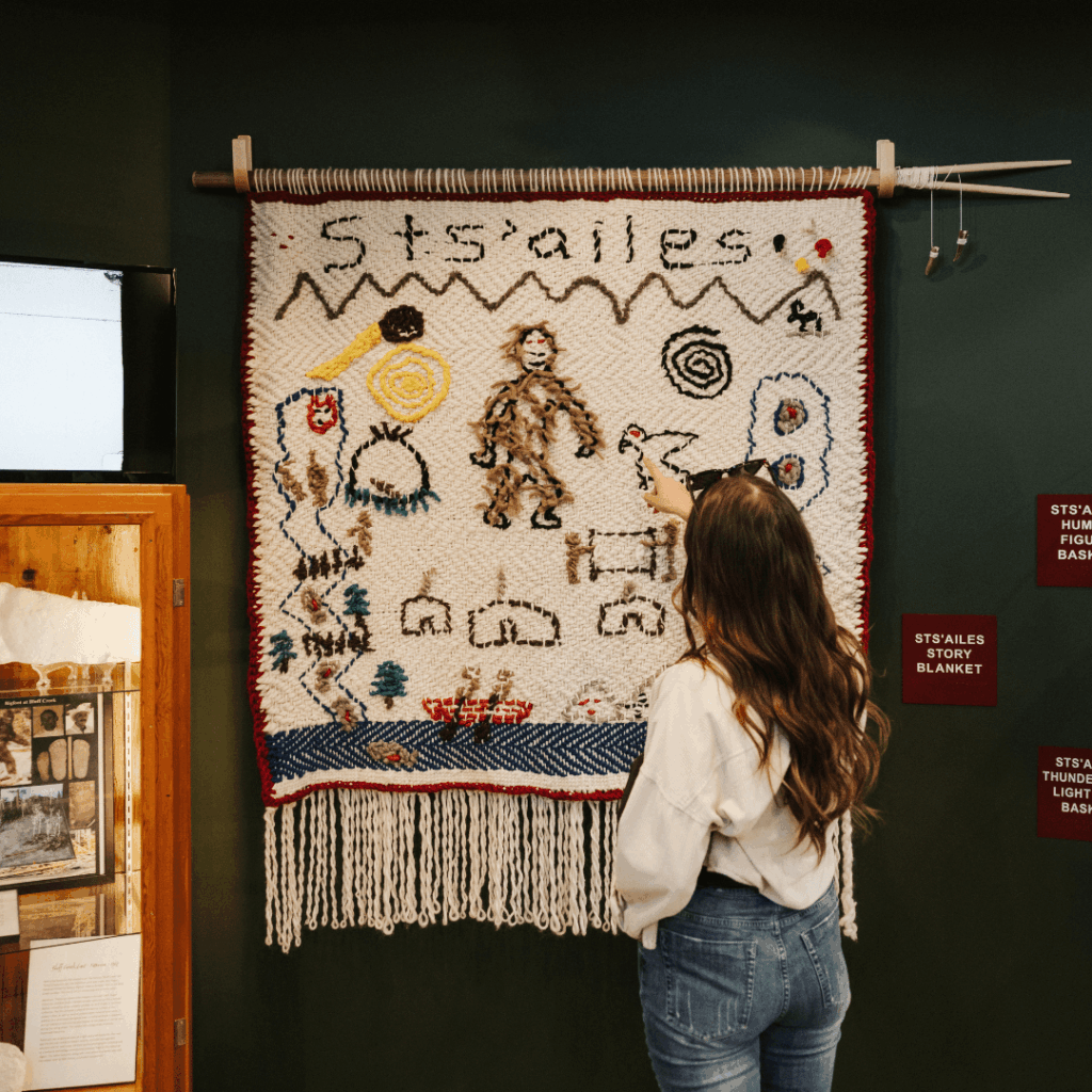 a woman looking at Indigenous art