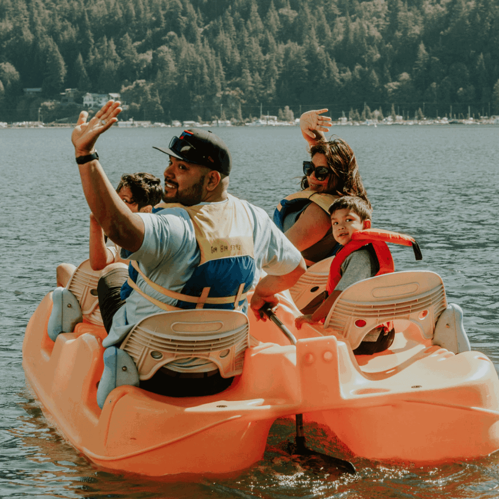 A man and a woman in a paddle boat with two young kids