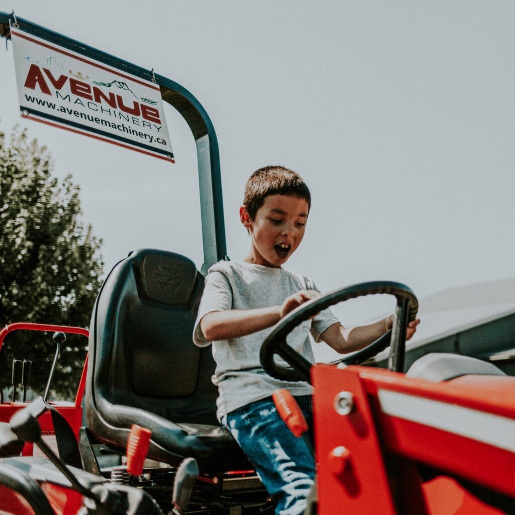 A young boy sitting a tractor