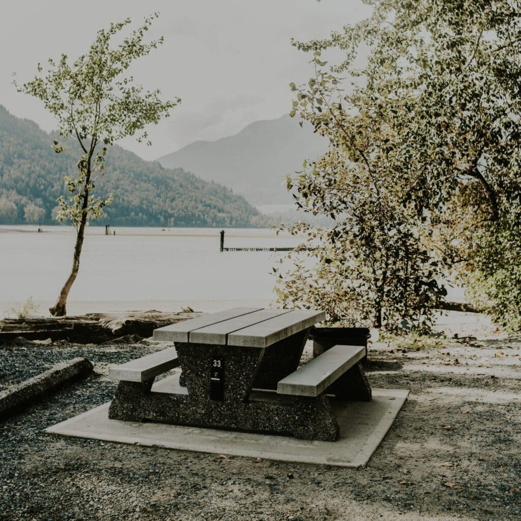 A picnic table with a lake in the background
