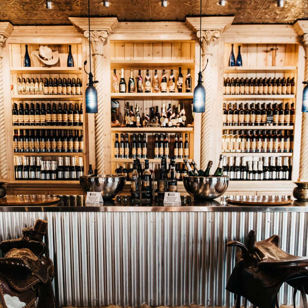 A bar with a wooden bar and lots of bottles.