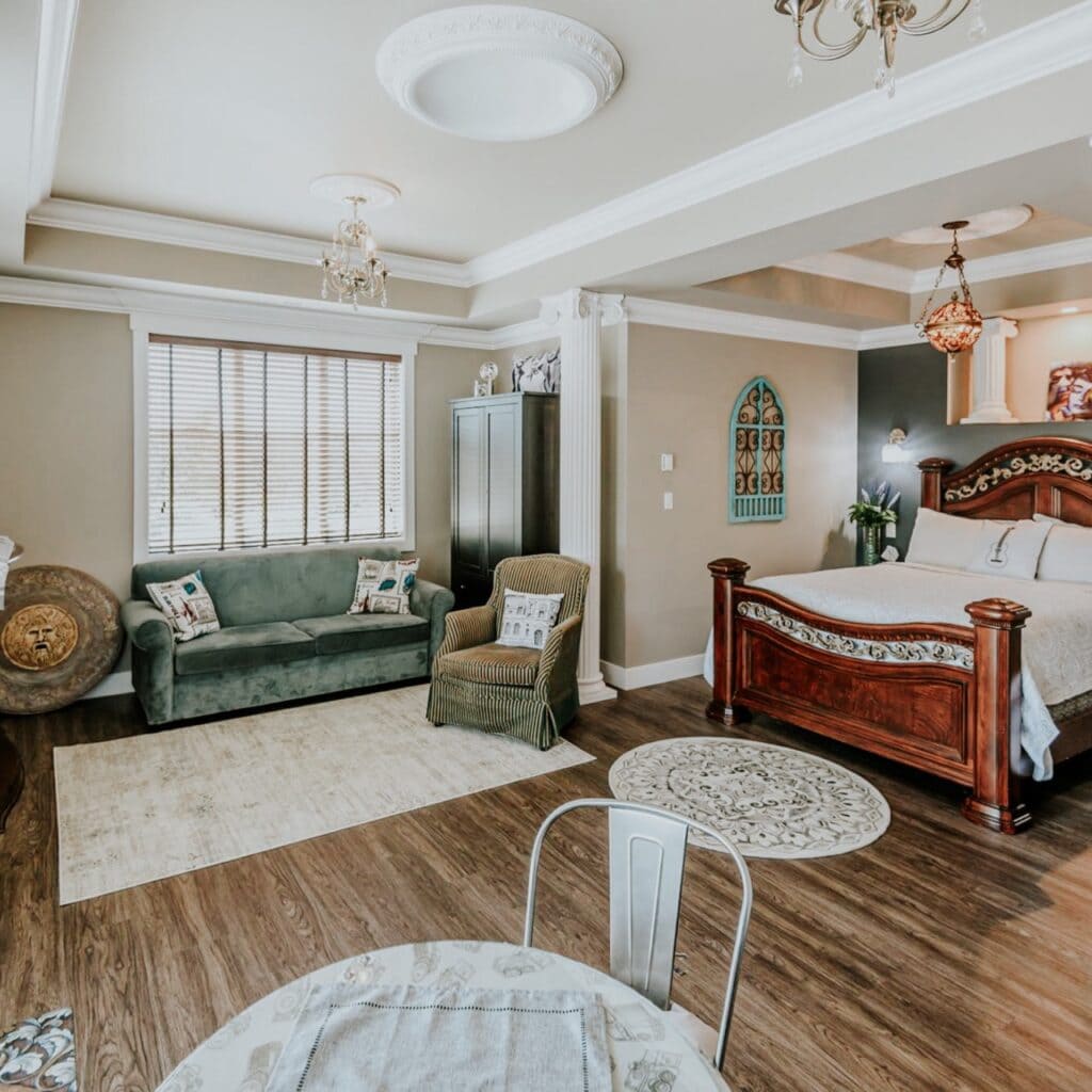 A beautiful cozy room with a couch, table and a large bed