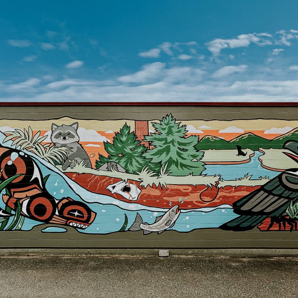 An Indigenous mural depicting a canoe, a bird, and a cat