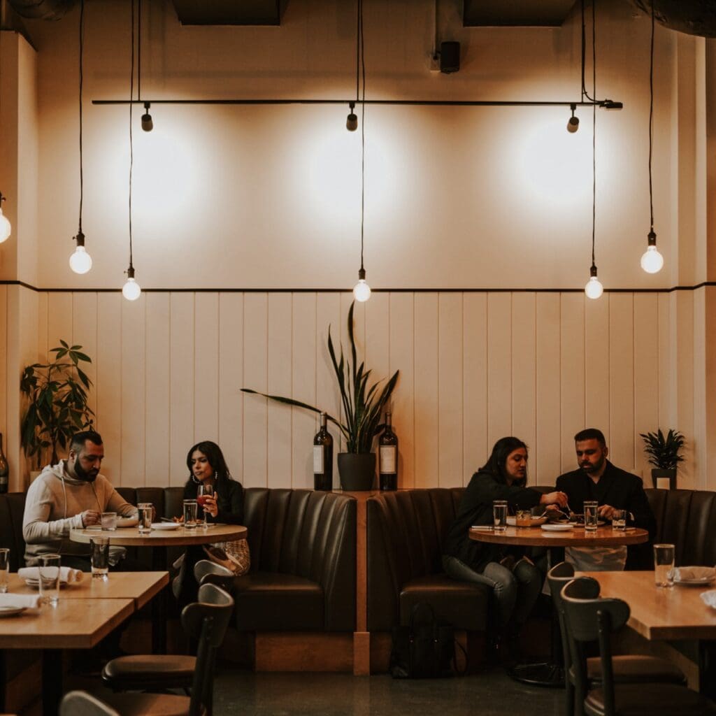 A photo of people sitting at booths in a restaurant