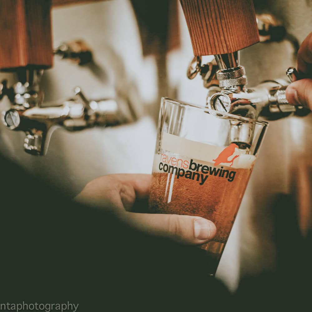 A person is pouring a beer into a glass.