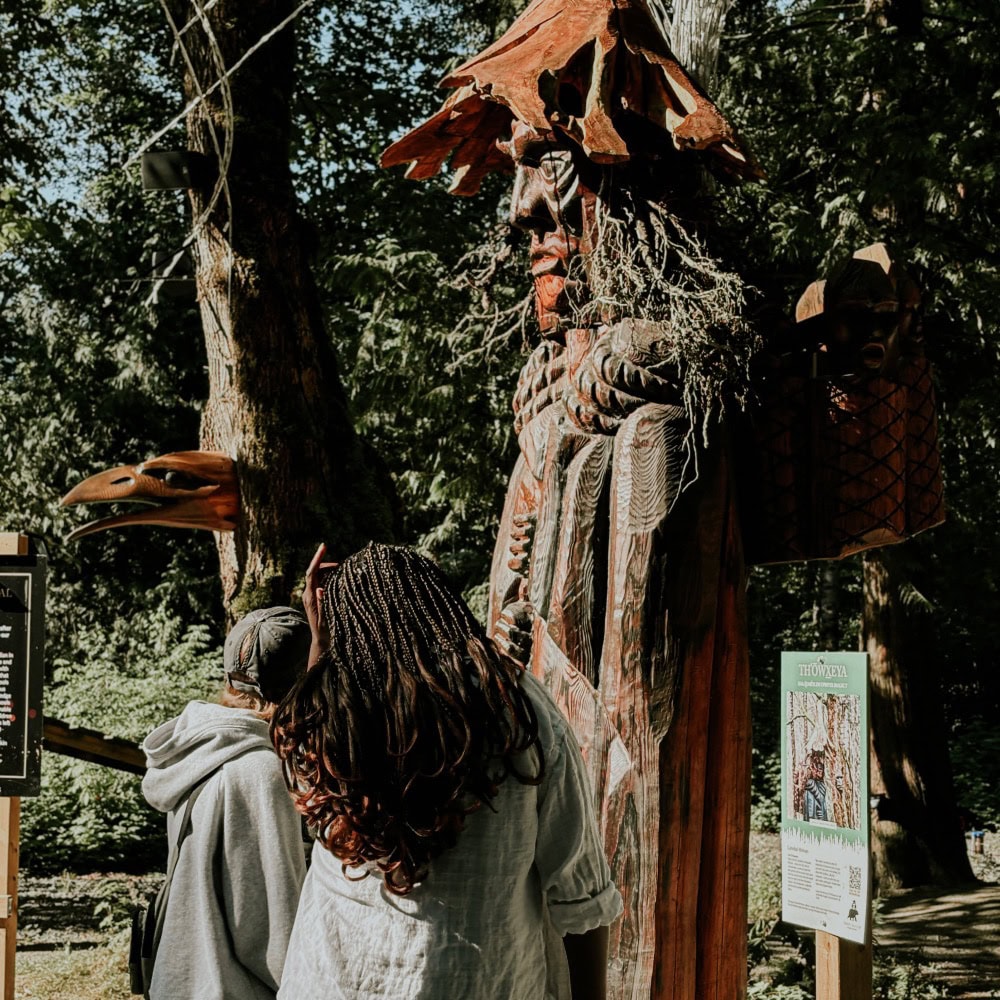 People looking up at an indigenous outdoor piece