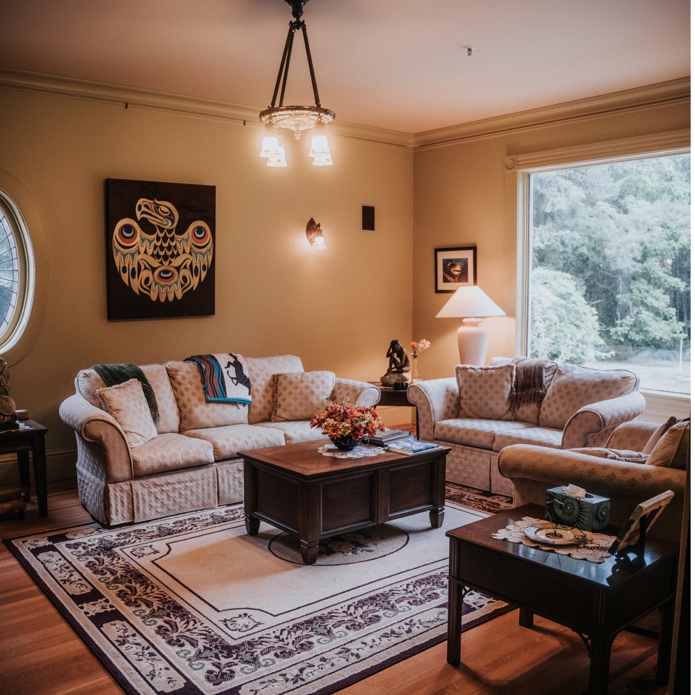 A cozy room with couches, coffee tables, and gorgeous indigenous art pieces