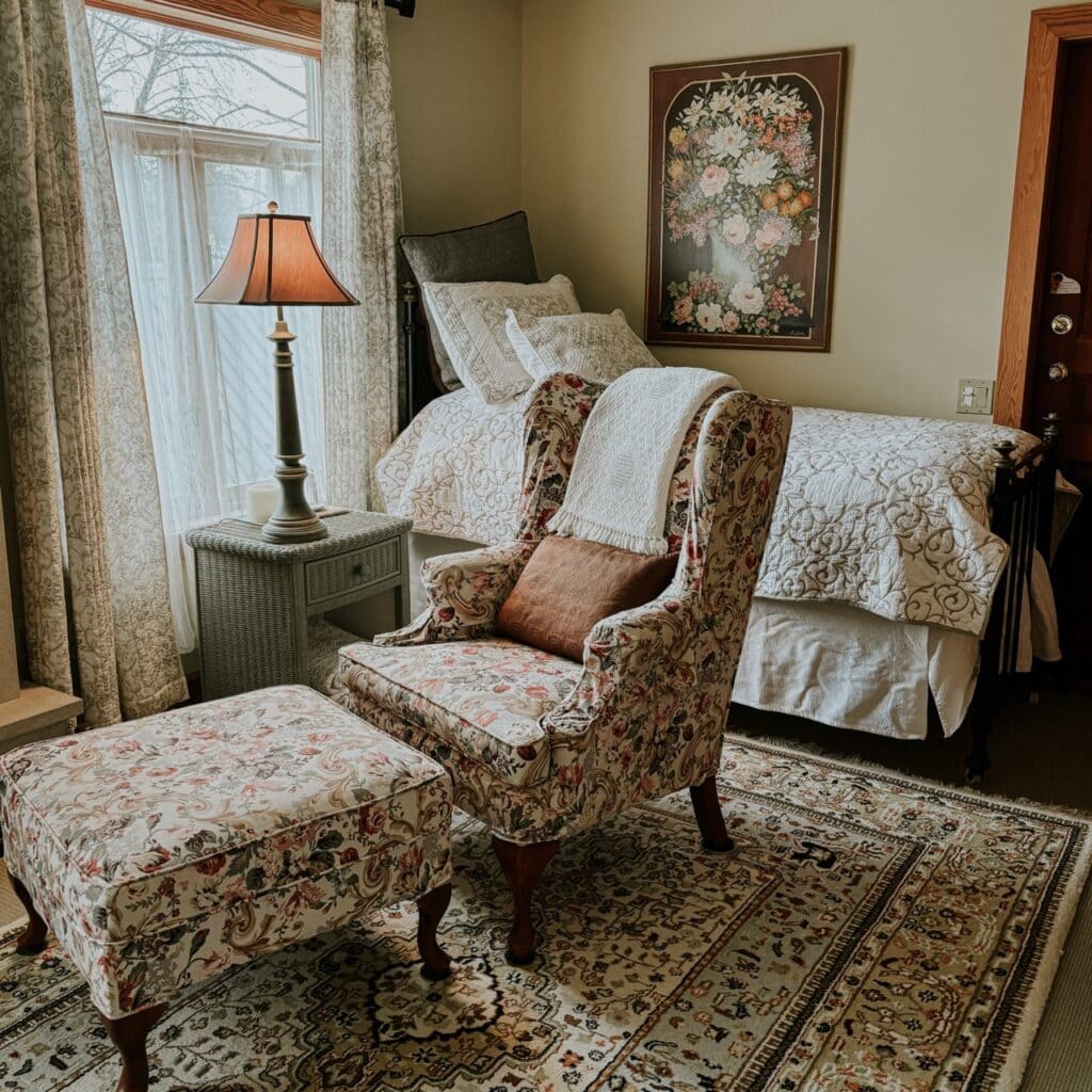 A quaint B&B room with a bed and a cozy seat
