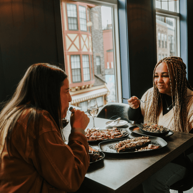 Two women sitting eating food