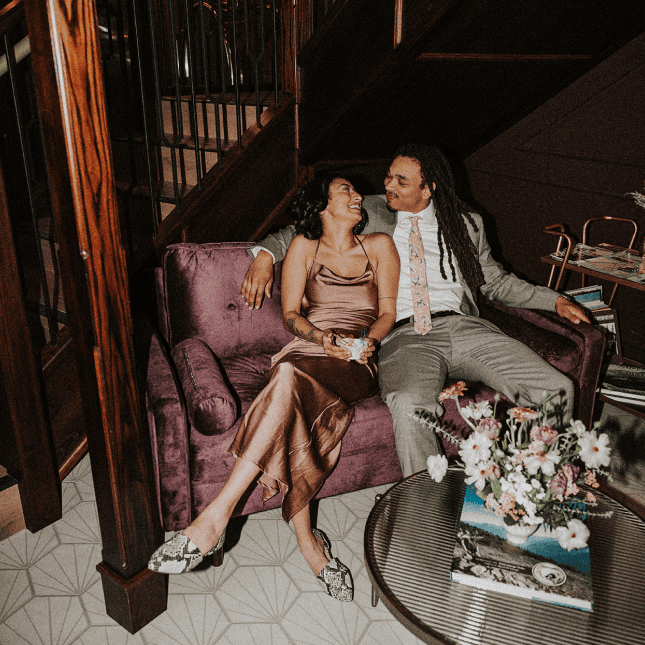 Two people looking at each other sitting side by side