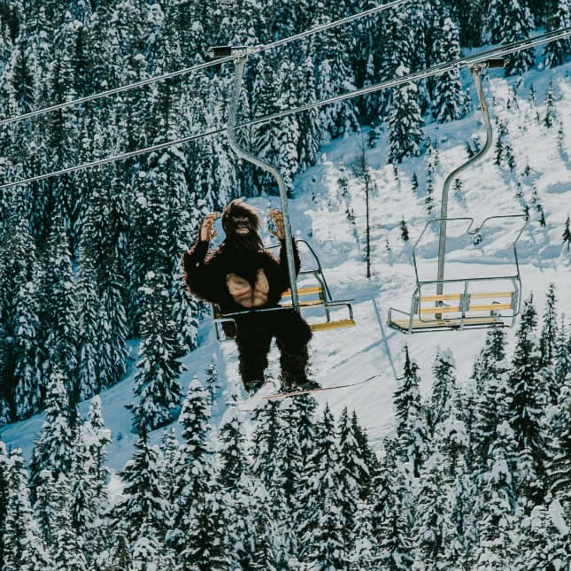 Person in Sasquatch suit riding on chair lift