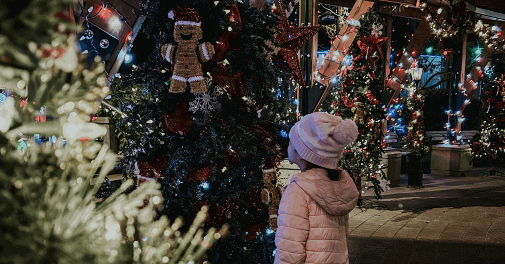 Little girl looking up at christmas tree