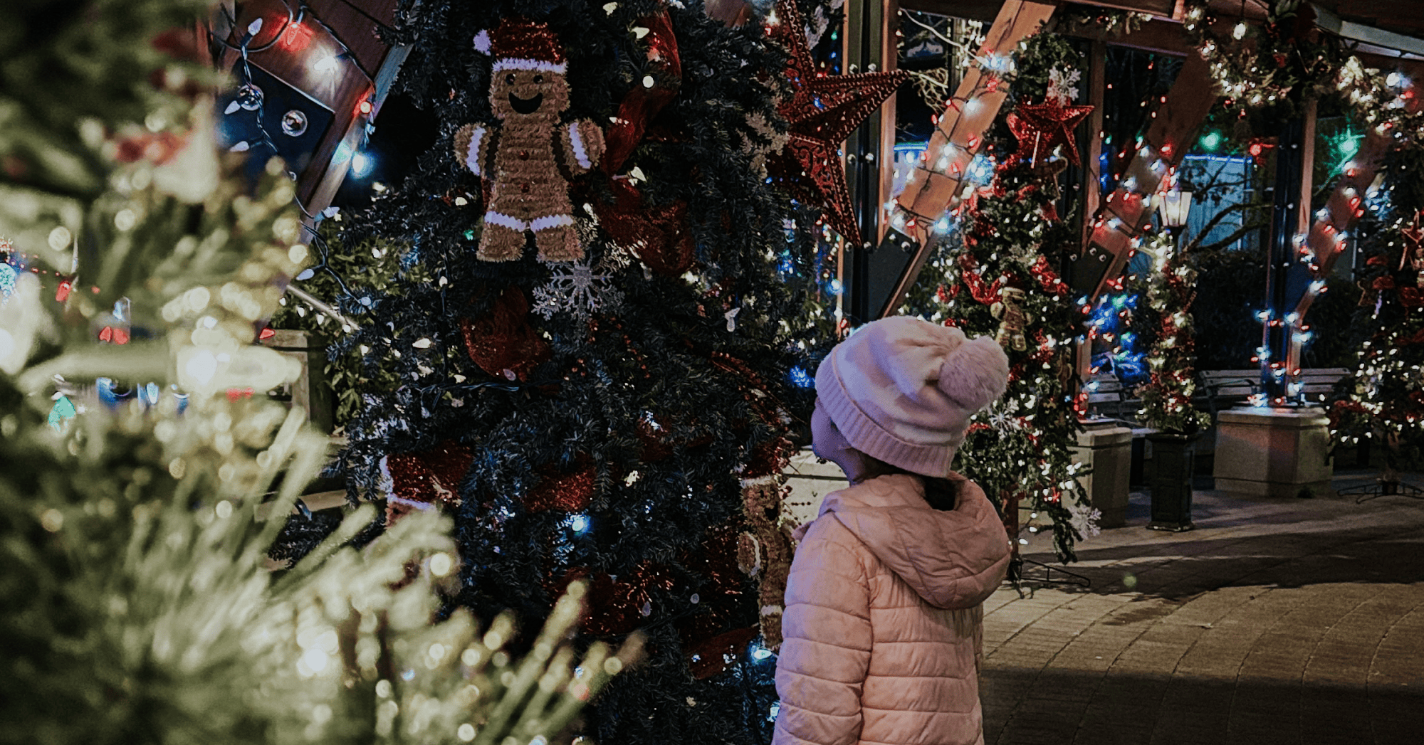 Little girl looking up at christmas tree