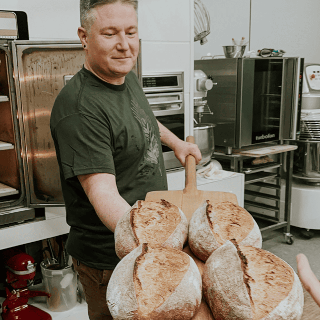 Man holding bread from the oven 