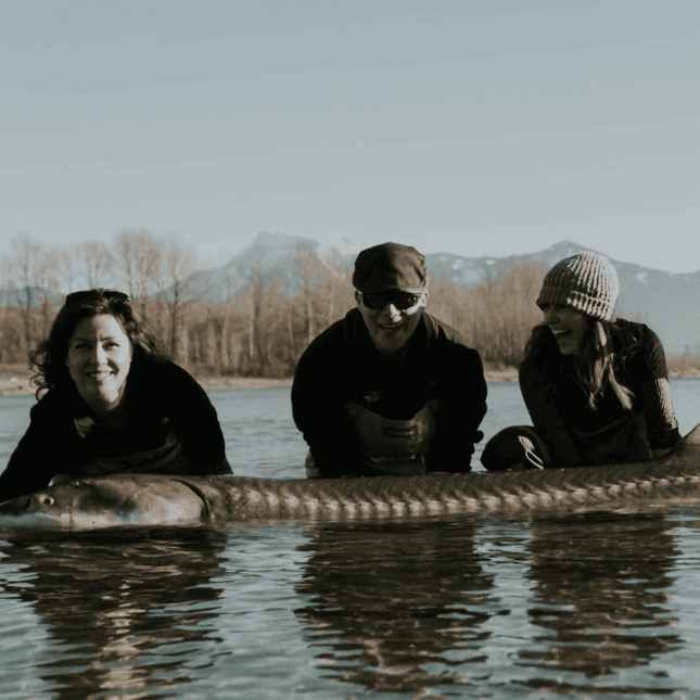 People holding sturgeon