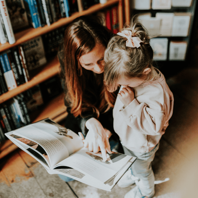Little girl and her mom looking at a book