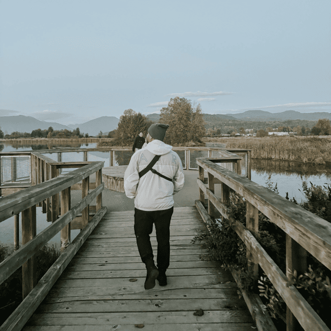 Man walking on bridge over a creek