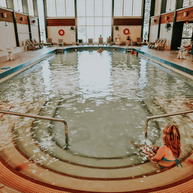 A big mineral pool with woman sitting inside 