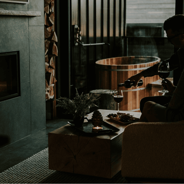 Person pouring a glass of wine in a dark room 