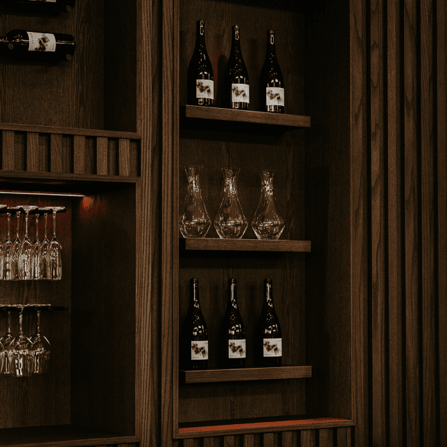 Dark wood shelving displaying bottles in a cozy, upscale tasting room.