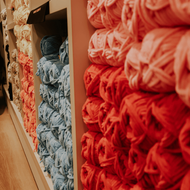 Close-up of colorful yarn arranged vertically in a display.