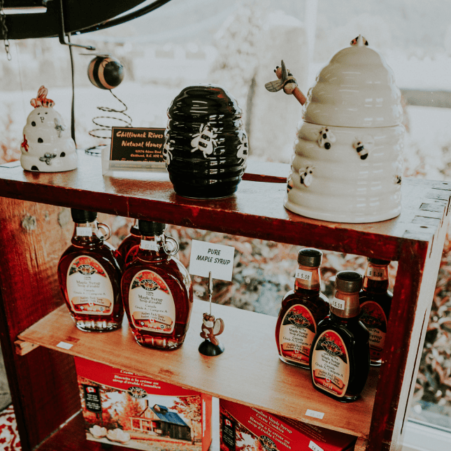 Display of bottled syrups arranged on a shop shelf.