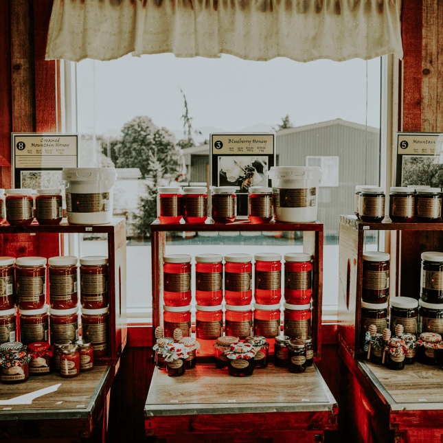 Interior view of a café retail area featuring shelves of packaged goods and honey.